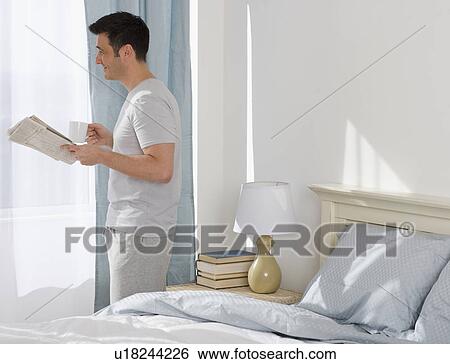 Man holding newspaper and coffee next to window View Large Photo Image Stock Photograph - Man holding newspaper and coffee next to window. Fotosearch