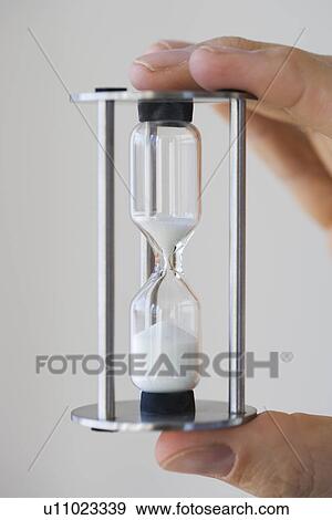 Man holding small hourglass View Large Photo Image Stock Photo - Man holding small hourglass. Fotosearch