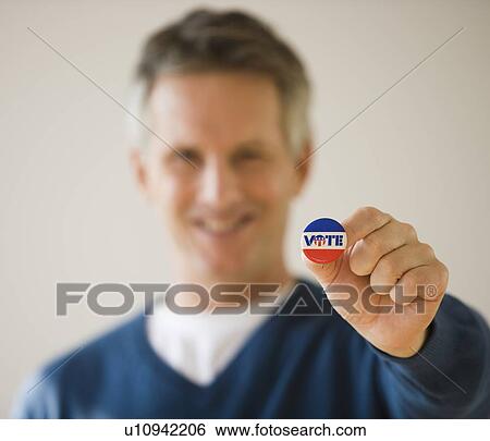 Stock Photograph - Man holding Vote button. Fotosearch