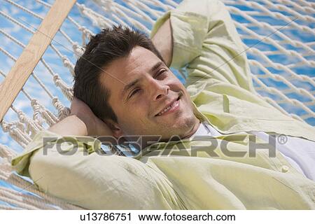 Man laying in hammock View Large Photo Image Stock Image - Man laying in hammock. Fotosearch