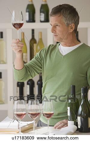 Man looking at glass of wine View Large Photo Image Stock Photo - Man looking at glass of wine. Fotosearch