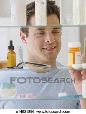 Man looking in medicine cabinet View Large Photo Image Stock Photograph - Man looking in medicine cabinet. Fotosearch