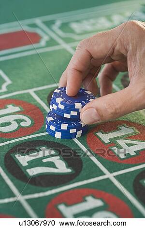 Man placing gambling chips on roulette table View Large Photo Image Stock Image - Man placing gambling chips on roulette table. Fotosearch
