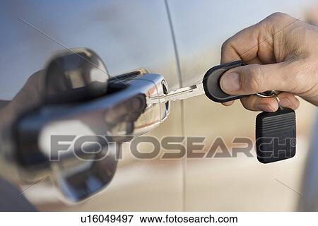 Man putting car key in door View Large Photo Image Stock Photo - Man putting car key in door. Fotosearch