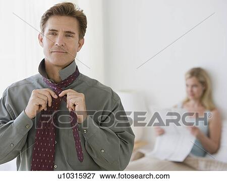 Man putting on tie View Large Photo Image Stock Photo - Man putting on tie. Fotosearch
