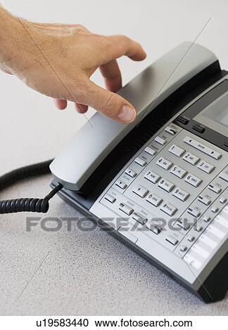 Stock Image - Man reaching for telephone receiver. Fotosearch