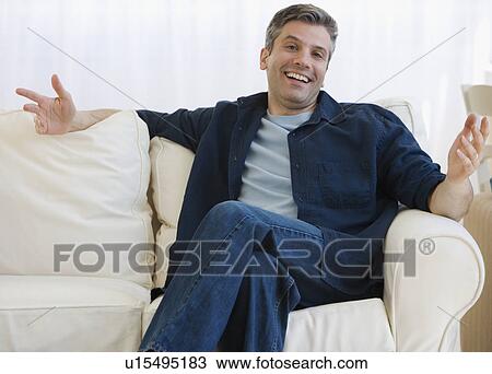 Man shrugging shoulders on sofa View Large Photo Image Stock Image - Man shrugging shoulders on sofa. Fotosearch