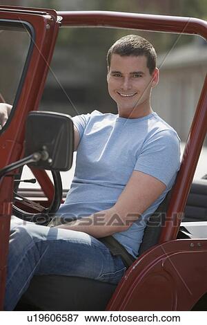 Stock Photo - Man sitting in jeep. Fotosearch