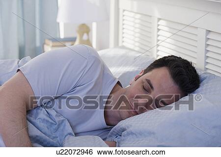 Stock Photograph - Man sleeping in bed. Fotosearch