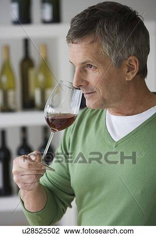 Stock Image - Man sniffing glass of wine. Fotosearch