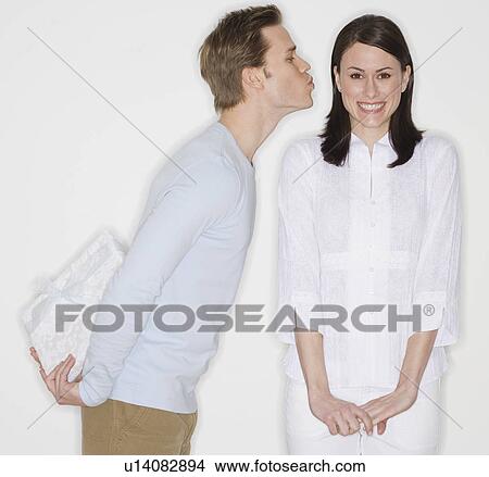 Man surprising girlfriend with gift View Large Photo Image Picture - Man surprising girlfriend with gift. Fotosearch