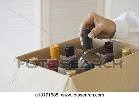 Man taking wine bottle out of case View Large Photo Image Stock Photography - Man taking wine bottle out of case. Fotosearch
