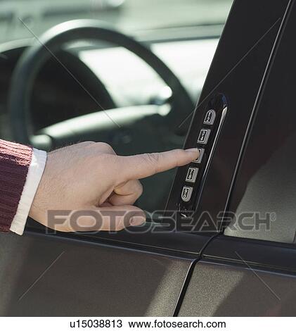 Stock Image - Man unlocking car door with keypad. Fotosearch
