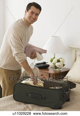 Man unpacking in hotel room View Large Photo Image Stock Photo - Man unpacking in hotel room. Fotosearch
