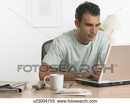 Man using laptop at table View Large Photo Image Stock Image - Man using laptop at table. Fotosearch