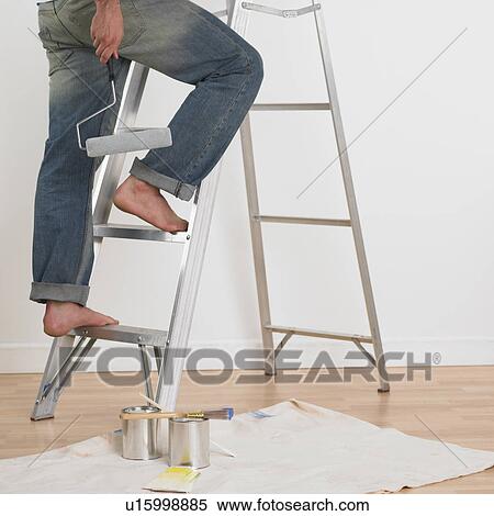 Stock Photography - Man walking up ladder with paint roller indoors . Fotosearch