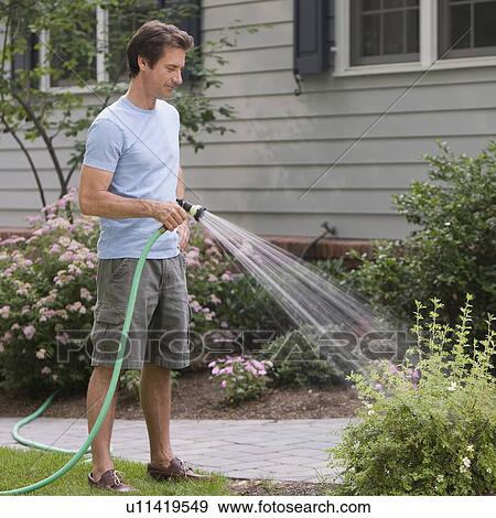 Stock Photo - Man watering plants. Fotosearch