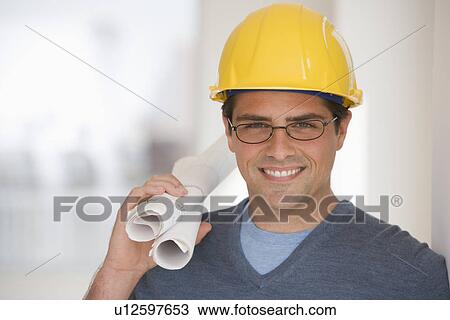 Man wearing hard hat and holding blueprints View Large Photo Image Stock Image - Man wearing hard hat and holding blueprints. Fotosearch