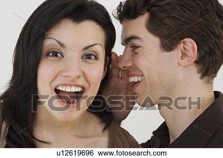 Man whispering in girlfriend's ear View Large Photo Image Stock Photograph - Man whispering in girlfriend's ear. Fotosearch