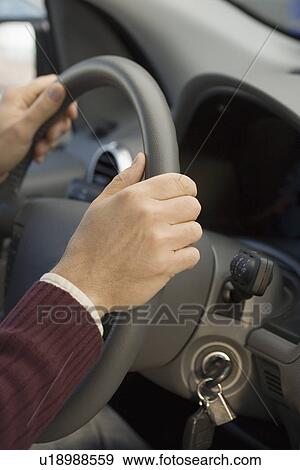 Stock Photo - Man’s hands on steering wheel. Fotosearch