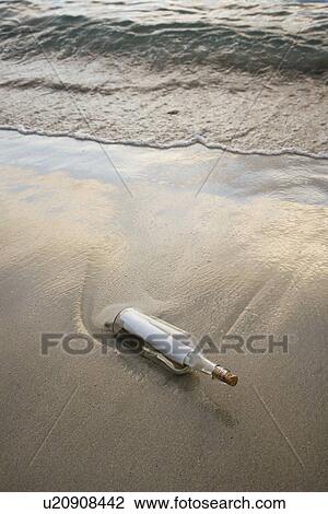 Stock Image - Message in bottle on beach. Fotosearch