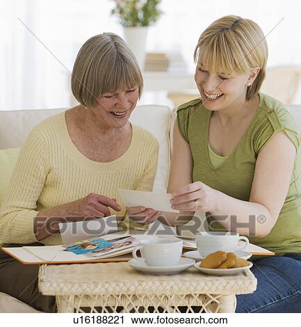 Mother and adult daughter looking at photographs View Large Photo Image Stock Image - Mother and adult daughter looking at photographs. Fotosearch