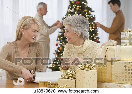 Mother and adult daughter wrapping Christmas gifts View Large Photo Image Stock Image - Mother and adult daughter wrapping Christmas gifts. Fotosearch