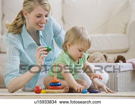 Picture - Mother and baby playing on floor. Fotosearch