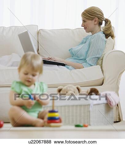 Mother and baby relaxing in living room View Large Photo Image Stock Photo - Mother and baby relaxing in living room. Fotosearch