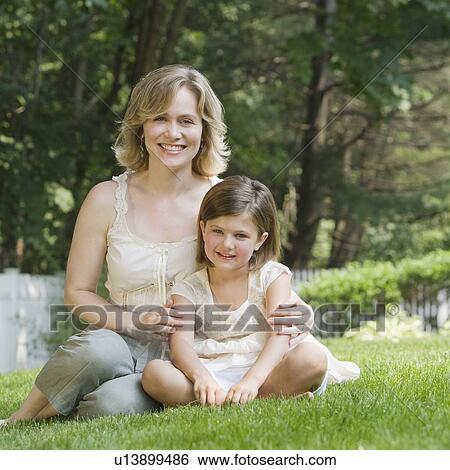 Mother and daughter hugging in grass View Large Photo Image Stock Photograph - Mother and daughter hugging in grass. Fotosearch