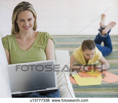 Mother and daughter relaxing in livingroom View Large Photo Image Stock Photo - Mother and daughter relaxing in livingroom. Fotosearch