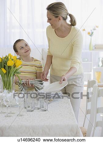 Mother and daughter setting table View Large Photo Image Stock Image - Mother and daughter setting table. Fotosearch