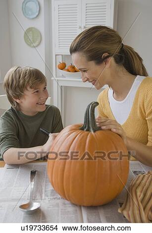 Picture - Mother and son decorating pumpkin. Fotosearch