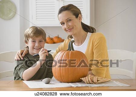 Mother and son decorating pumpkin View Large Photo Image Stock Photo - Mother and son decorating pumpkin. Fotosearch