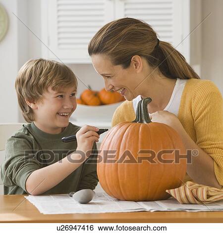 Mother and son decorating pumpkin View Large Photo Image Stock Photograph - Mother and son decorating pumpkin. Fotosearch