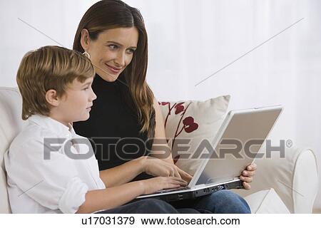Stock Photo - Mother and son looking at laptop. Fotosearch