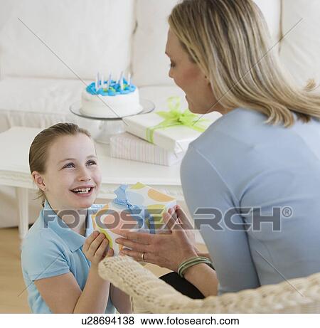 Stock Photo - Mother giving daughter birthday gift. Fotosearch