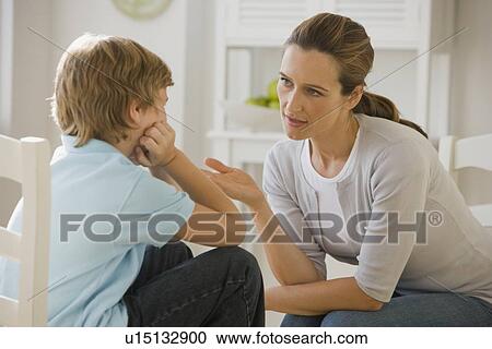 Stock Image - Mother having discussion with son. Fotosearch