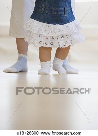 Stock Image - Mother helping baby walk. Fotosearch