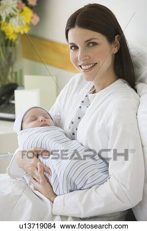 Mother holding newborn in hospital View Large Photo Image Picture - Mother holding newborn in hospital. Fotosearch