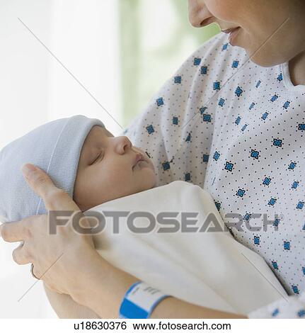 Mother holding newborn in hospital View Large Photo Image Stock Photograph - Mother holding newborn in hospital. Fotosearch