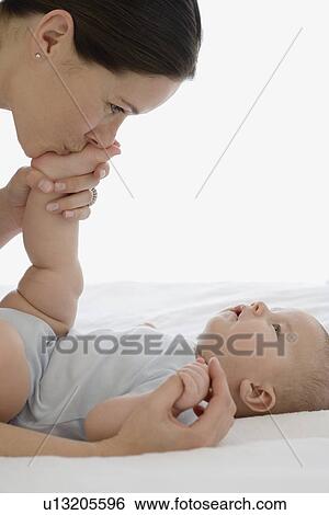 Mother kissing baby’s foot View Large Photo Image Stock Photograph - Mother kissing baby’s foot. Fotosearch