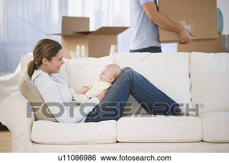 Stock Photograph - Mother smiling at baby in new house. Fotosearch