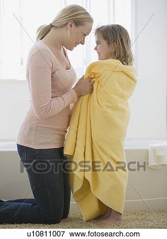 Mother smiling at daughter wrapped in towel View Large Photo Image Stock Photo - Mother smiling at daughter wrapped in towel. Fotosearch