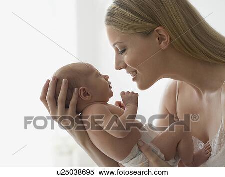 Stock Photography - Mother smiling at newborn baby. Fotosearch