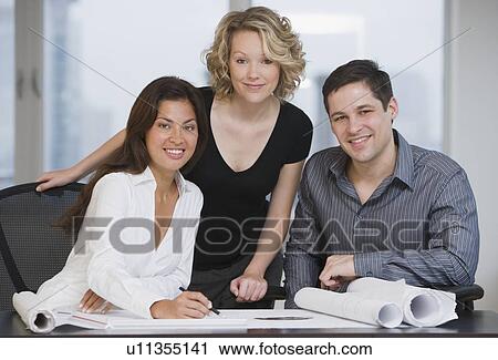 Multi-ethnic businesspeople with blueprints View Large Photo Image Stock Image - Multi-ethnic businesspeople with blueprints. Fotosearch