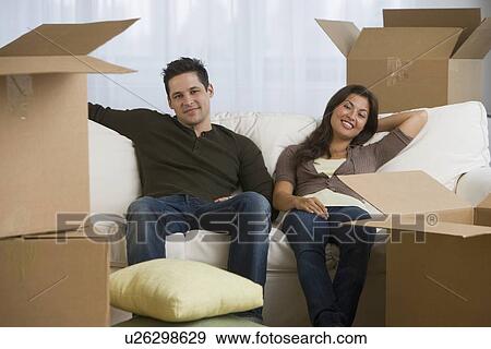 Multi-ethnic couple surrounded by moving boxes View Large Photo Image Stock Photo - Multi-ethnic couple surrounded by moving boxes. Fotosearch