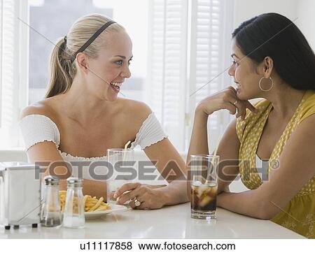Multi-ethnic friends eating at diner View Large Photo Image Stock Photo - Multi-ethnic friends eating at diner. Fotosearch