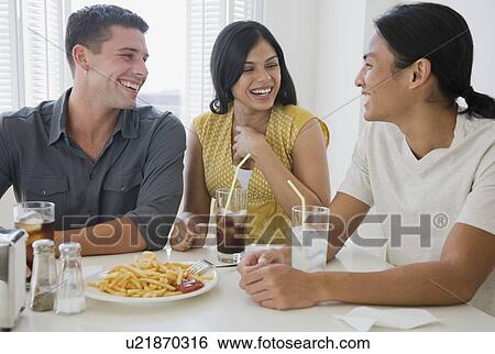 Multi-ethnic friends eating at diner View Large Photo Image Stock Photograph - Multi-ethnic friends eating at diner. Fotosearch