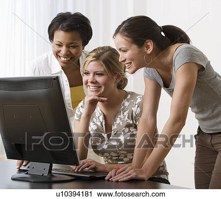 Multi-ethnic women looking at computer View Large Photo Image Stock Image - Multi-ethnic women looking at computer. Fotosearch